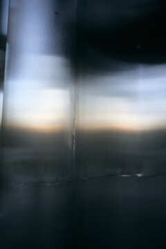 Abstract metal surface with soft sunset light reflection and smooth curved industrial texture