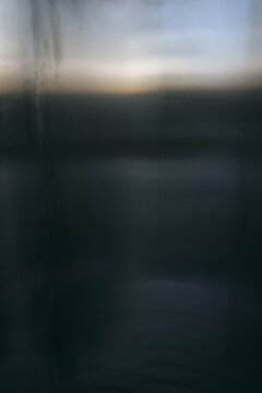 Abstract blurred background with soft gradient transition from dark grey to light horizon line