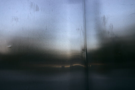 Abstract background of brushed stainless steel metal surface with soft light reflections