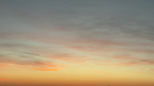 Timelapse of colorful evening sky with moving cirrus clouds