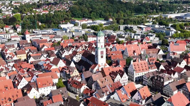 Malerische Panorama-Luftaufnahme von Biberach an der Ri&szlig; mit der historischen Altstadt, markanten Kircht&uuml;rmen und herbstlichen B&auml;umen unter blauem Himmel.