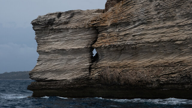 Layered limestone cliff rising from the Mediterranean Sea in Bonifacio