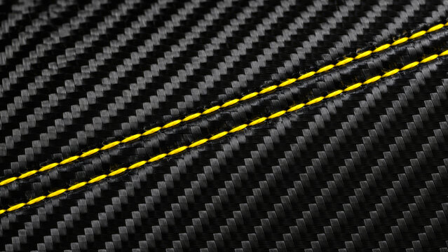 Close-up carbon fiber texture in black with yellow highlight