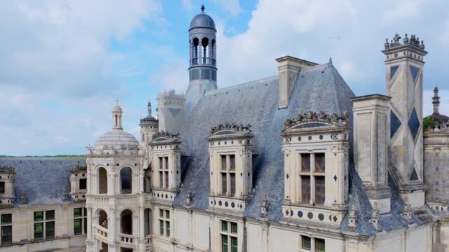 Ornate Renaissance roofline with slate roofs, carved dormer windows, tall chimney stacks and a domed lantern turret seen from the castle roof terrace, Chateau de Chambord, Loire Valley, France