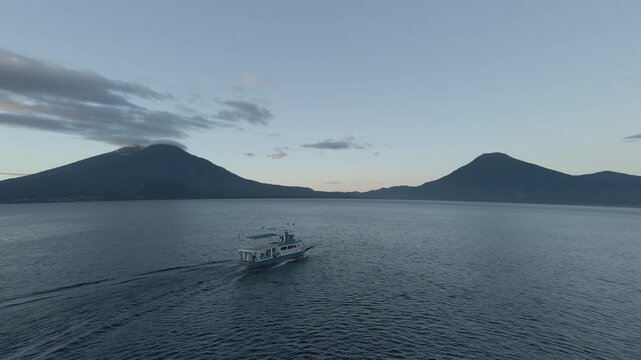 the mayestic Lake atitlan and volcanoes in guatemala 
drone shot at sunrise.

