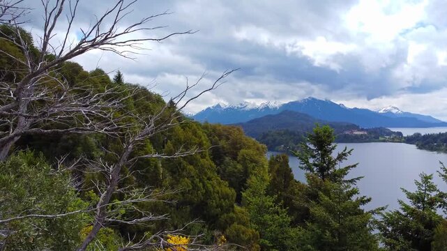 Aerial 4K drone view of a lakeside resort and Nahuel Huapi Lake surrounded by forest and mountains, Bariloche, Patagonia