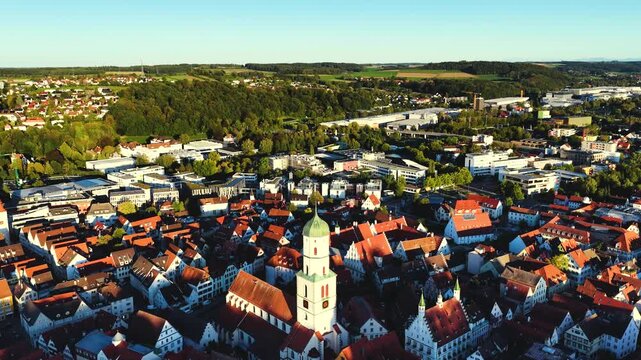 Malerische Panorama-Luftaufnahme von Biberach an der Ri&szlig; mit der historischen Altstadt, markanten Kircht&uuml;rmen und herbstlichen B&auml;umen unter blauem Himmel.