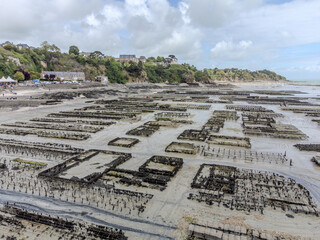 Aerial drone view of underwater oyster farms in Cancale, Brittany, exposed during low tide, raditional sustainable aquaculture and production of premium French oysters, France © barmalini