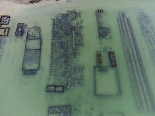 Aerial drone view of underwater oyster farms in Cancale, Brittany, exposed during low tide, raditional sustainable aquaculture and production of premium French oysters, France © barmalini