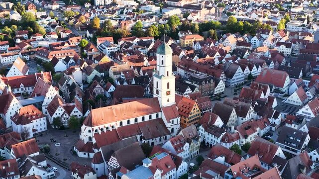 Malerische Panorama-Luftaufnahme von Biberach an der Ri&szlig; mit der historischen Altstadt, markanten Kircht&uuml;rmen und herbstlichen B&auml;umen unter blauem Himmel.