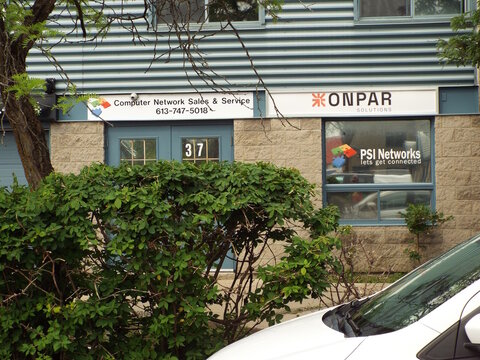 Gloucester, Ontario, Canada &ndash; July 31, 2026: The "Computer Network Sales and Service, Onpar Solutions, and PSI Networks" storefront signs are displayed above a commercial building entrance on Polytek 