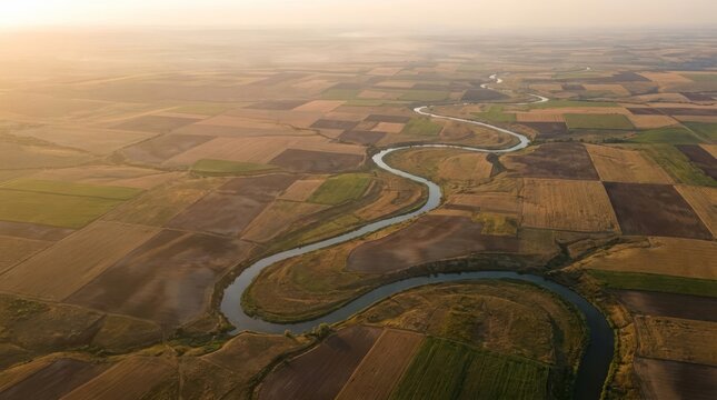 Aerial view of winding river through agricultural fields.