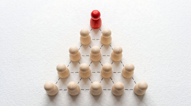 Red wooden peg leader standing at the top of a pyramid of wooden figures connected by dashed lines representing corporate hierarchy leadership teamwork and organization structure