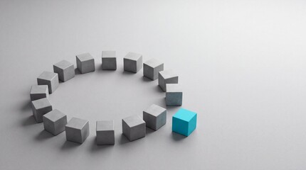 Fototapeta premium Unique bright blue cube standing out from a circle of identical grey concrete blocks on a minimalist surface, representing leadership, individuality, and core business concept metaphor.