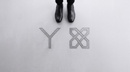 Fototapeta premium Top down view of a person standing before a Y junction symbol and a complex interlocking knot icon representing choice, strategic decision making, and conceptual path selection in business.