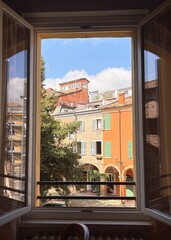 Fototapeta premium Scenic view of cozy Italian alleyway and old architecture from a residential window in Modena