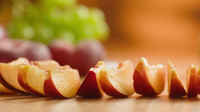 Chef cutting peach, apricot, nectarine and grapes with knife, preparing fruit salad for breakfast, homemade jam and juice
