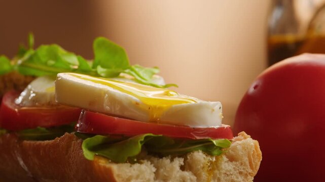 Sandwich with tomato and mozzarella, Italian style caprese baguette with fresh arugula, vegetarian bocadillo close up for cafe breakfast menu