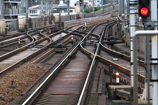 Railway tracks diverging with red signal in urban setting