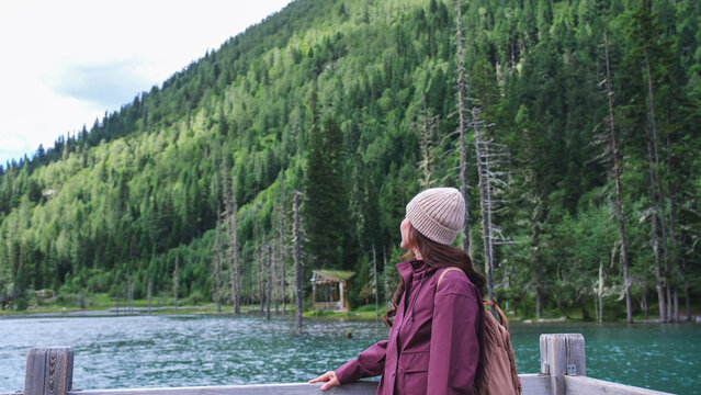 A woman looking at a beautiful lake and mountain views in summertime, Chengdu, China