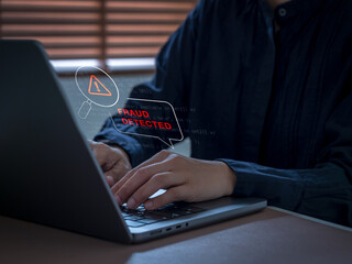 Naklejka na ściany i meble Security analyst using laptop computer with fraud detected warning interface. Real-time transaction monitoring, suspicious activity detection, financial security and digital fraud prevention concepts.