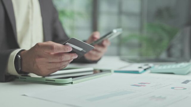 Conducting secure payment online, investor completes payment process after review market investment data at office desk.