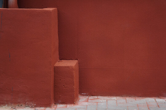 A close-up view of a red wall with a small block structure