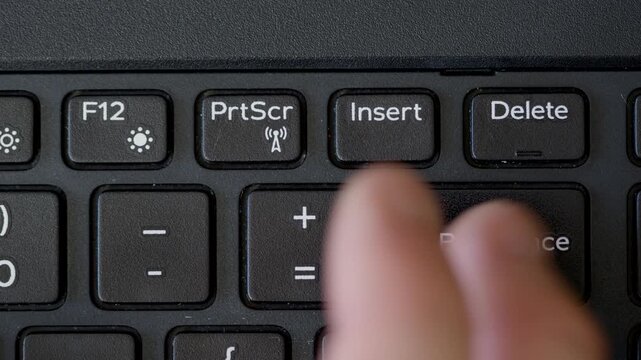 Close-Up of a Finger Pressing a Computer Keyboard Key with Function and Navigation Buttons
