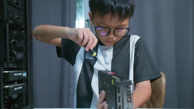 Young boy concentrating while repairing and assembling hardware inside an open desktop computer case at home, learning technology and problem solving skills