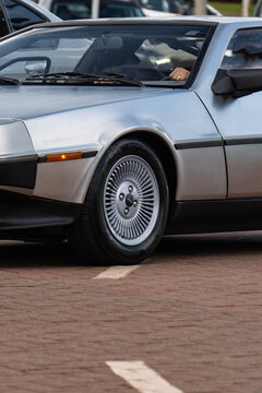 Silver DMC DeLorean Classic Sports Car Front Wheel Detail Parked On Brick Paved Street