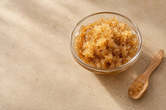 Zuckerpeeling in einer Glasschale mit Holzspatel