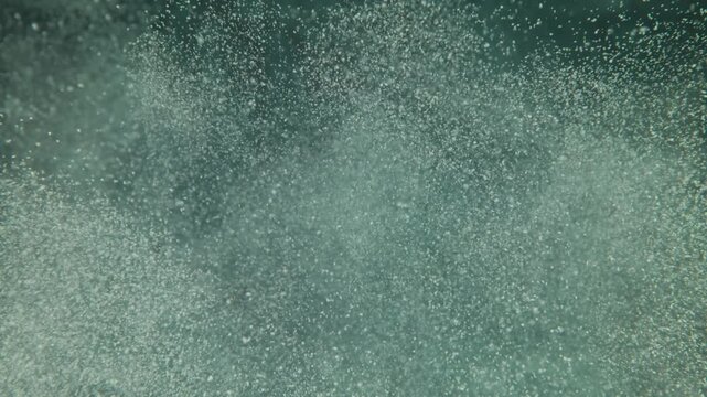 Abstract underwater background featuring rapid motion of oxygen bubbles rising towards surface in deep clear blue pool water.