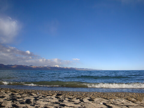 Scenic beach with clear blue water and sandy shore under bright sky