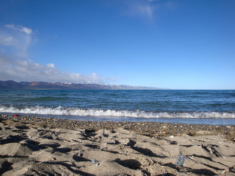 Scenic beach with clear blue water and sandy shore under bright sky