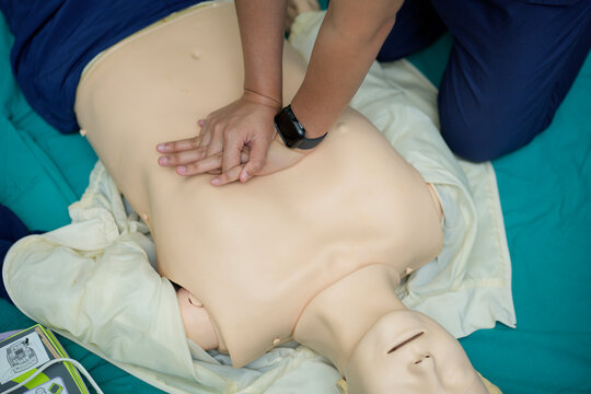 Demonstration of chest compressions during basic life support (BLS) CPR training on a medical mannequin. 