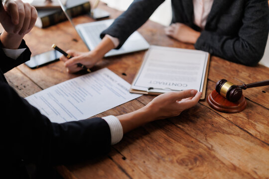 Lawyer and client discussing contract agreement in office, preparing for signature with legal consultation
