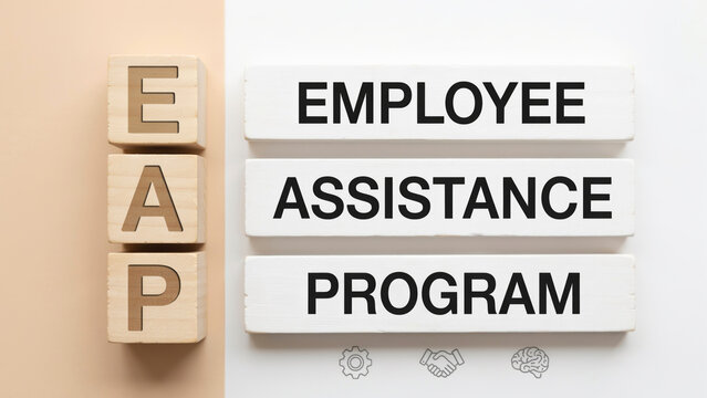 Employee assistance program text on wooden blocks arranged with arranged minimalist white letters phrases spelling white beige surface spelling out professional eap