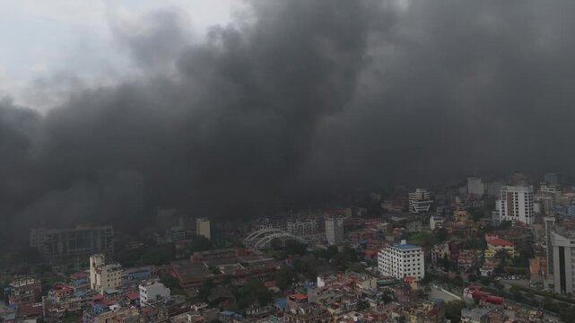 Dense black smoke rising dangerously above city buildings during a protest in Kathmandu.