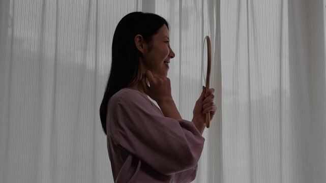 美容施術後の自分の姿を鏡で見つめる女性