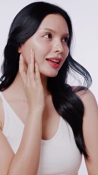 A beautiful Asian woman with clean glowing skin smiles at the camera. Perfect for skincare, beauty product, and cosmetic advertisements.