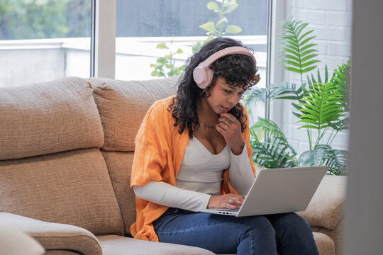 Online student with a laptop and headphones at home, focused on the course