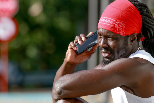 African American man talking on smartphone outdoors, urban sport lifestyle portrait