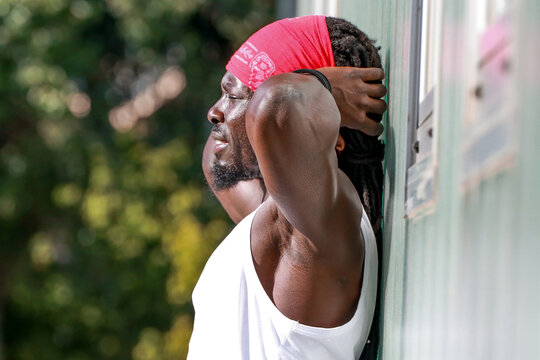 Black athlete outdoors, resting and focused on motivation