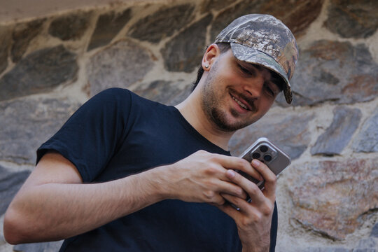 Young person with a mobile phone searching or chatting outdoors.