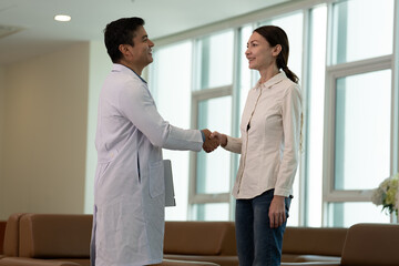 Doctor greeting female patient with handshake during medical consultation in medical office with female patient © Stock Media Labs
