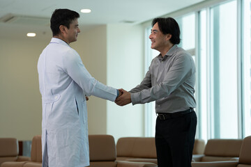 Doctor greeting patient with handshake during medical consultation in medical office in bright clinical setting © Stock Media Labs