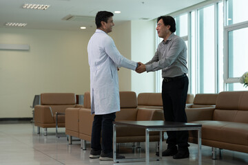 Doctor greeting patient with handshake during medical consultation in clinic waiting room near bright window near bright window © Stock Media Labs