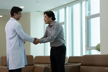 Medical professional greeting patient with handshake during medical consultation in hospital waiting room in bright clinical setting © Stock Media Labs