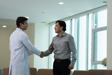 Doctor greeting patient with handshake during medical consultation in medical office in bright clinical setting in bright clinical setting © Stock Media Labs
