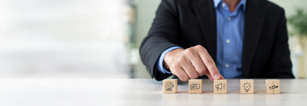 Education marketing strategy and content planning concpt. A businessman arranges education marketing icons. Content strategy, communication, online learning, audience engagement and business growth.